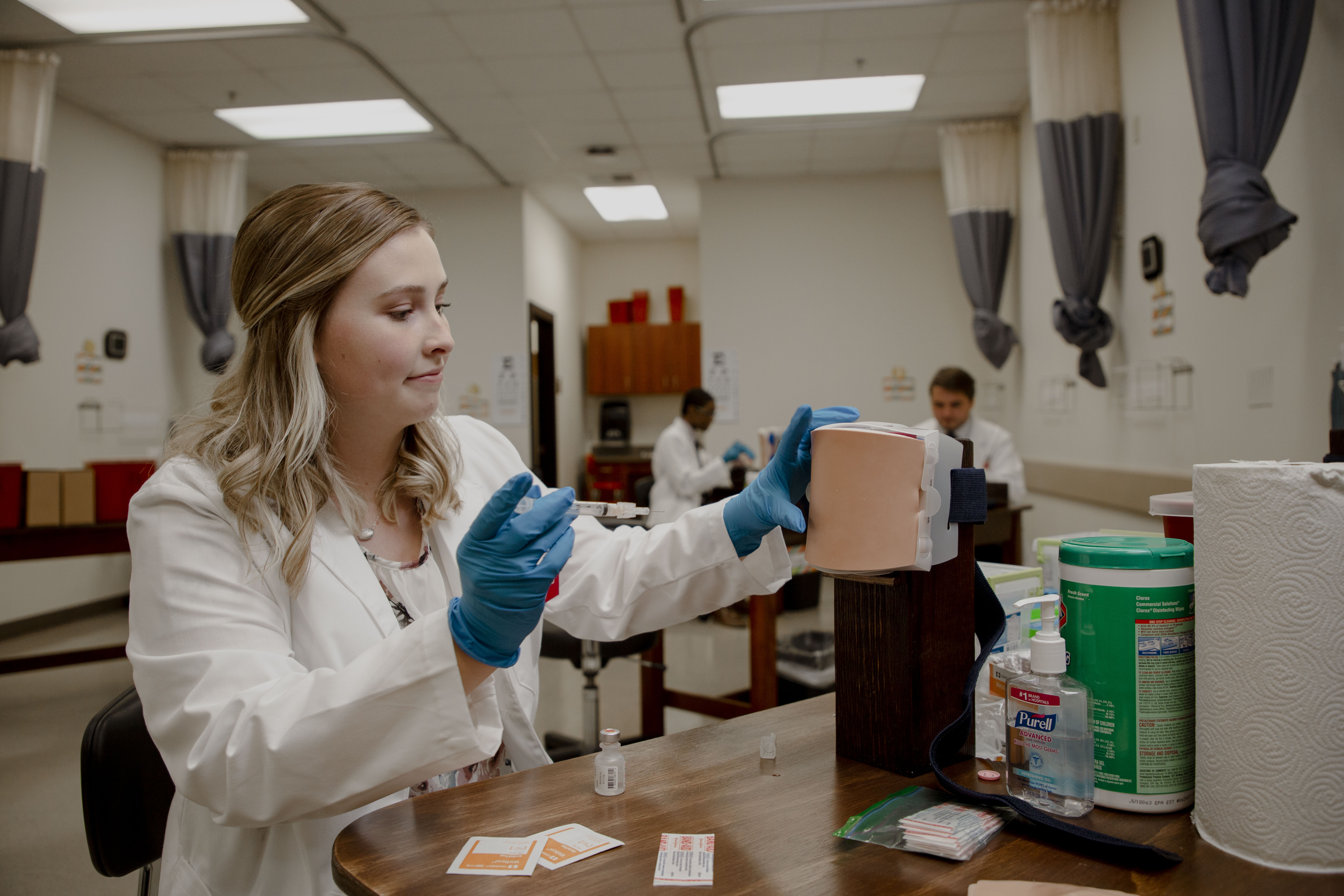 Female student practicing the administration of immunizations in a simulated environment
