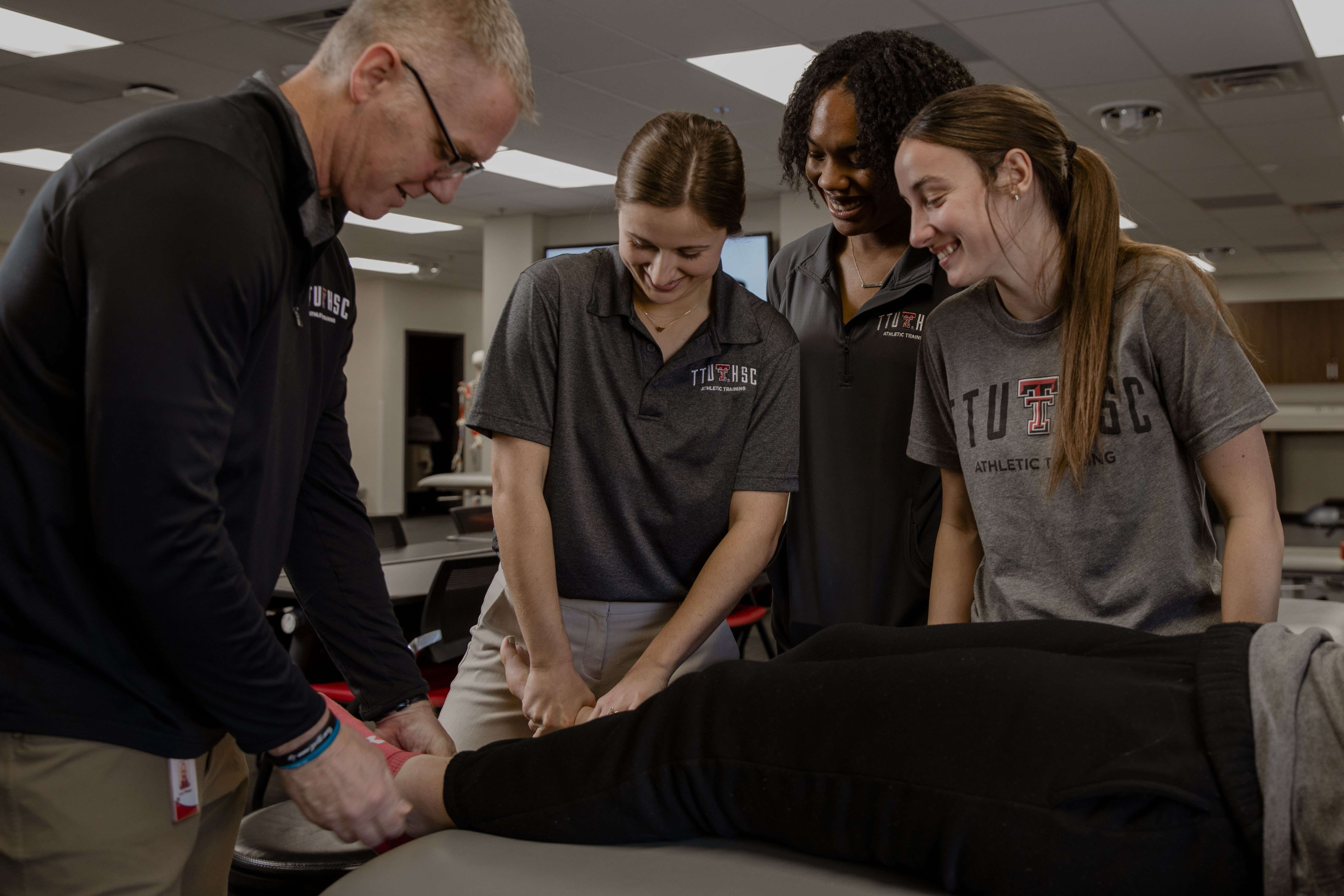 A SHP faculty member demonstrating a technique to three students